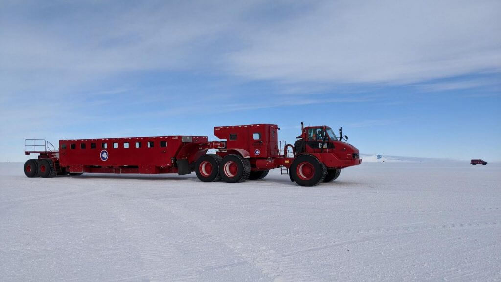 An image of an Antarctic vehicle with comically large tires, and thick insulated walls and survival gear inside, that transports personnel to and from the ice runway and McMurdo Station.